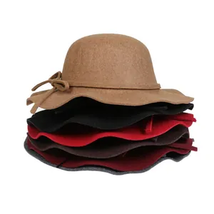 Close-up of elegant wool felt hats with wavy brims and bow details in various colors