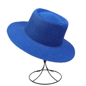 Detailed weave texture of royal blue straw flat top hat on a metal stand