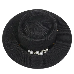 Detail of elegant black straw hat with white flowers and pearls on a satin ribbon