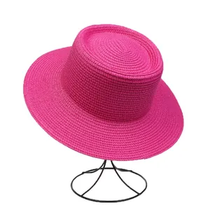 Detailed view of the woven texture and magenta color on this summer flat top straw hat