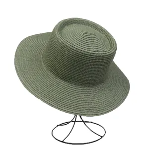 Detailed texture of olive green woven straw flat top boater hat on minimalist display stand