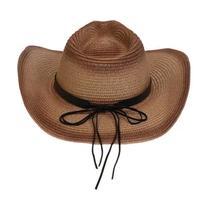 Detalle de la paja tejida de un sombrero de sol con banda de cuero negro y flecos