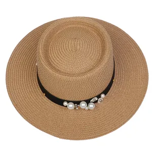Detail view of woven straw hat featuring elegant pearl and white flower ornaments