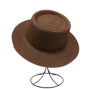 Close-up of dark brown straw weave texture on a flat-top French style boater hat