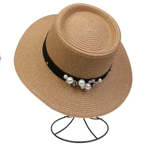 Detailed view of woven boater hat featuring elegant pearl and flower embellishments
