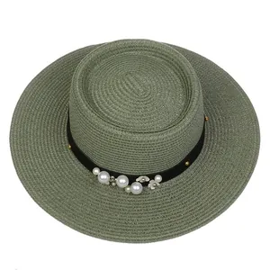 Detailed top view of olive green straw hat with pearl and floral decorations