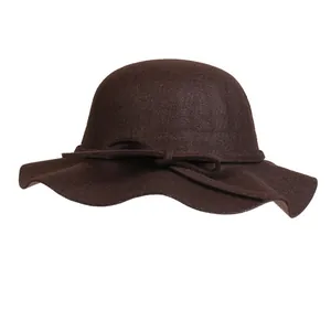Detail of dark coffee wool felt dome hat featuring an elegant wavy brim and a small bow tie