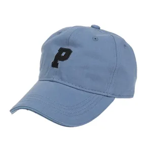 Detalle de gorra de béisbol azul claro con letra P bordada en negro sobre tela de algodón