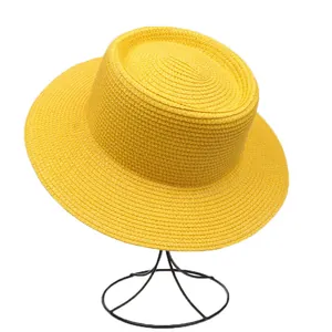 Detailed weave texture of vibrant yellow flat top boater straw hat on a display stand