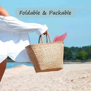 Chapeau Panama rose pliable rangé dans un sac de plage en paille au bord de mer