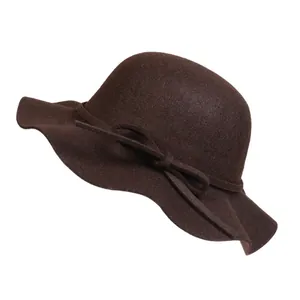 Detail of elegant dark brown wool felt hat with wavy brim and delicate bow accent