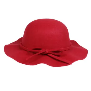 Detail of red wool felt hat with wavy brim and elegant bow ribbon decoration