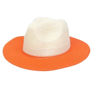 Detail showing two-tone woven straw hat with beige crown and vibrant orange wide brim