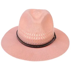 Close-up of pink woven sun hat featuring a dark leather band with silver metal rivets