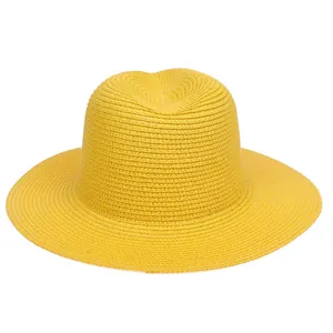 Detailed macro view of bright yellow woven paper straw texture on a sun hat
