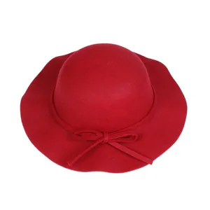 Detail view of the elegant red wool felt dome hat with wavy brim and bow decoration