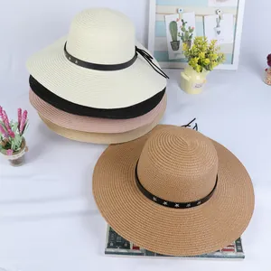 Flat lay of wide brim straw hats in various colors with star studded leather bands