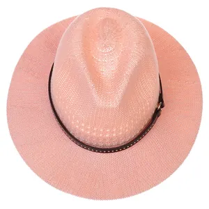 Detail of pink woven straw hat featuring brown leather band with silver metal studs