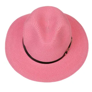 Détail du chapeau Panama rose avec ruban en cuir noir et boucle en métal doré