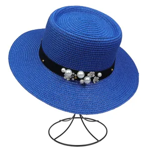 Close-up of royal blue straw hat featuring pearl and silver flower trim details