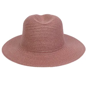 Detail of wide-brimmed dusty pink straw hat showing fine woven texture and crown dent