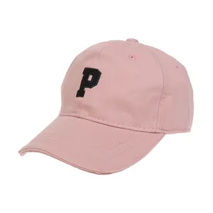 Primer plano de gorra rosa de algodón con letra P negra bordada y costuras detalladas