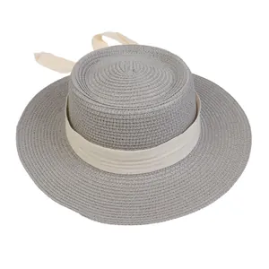 Close-up of gray straw hat featuring cream ribbon bow and fine herringbone texture
