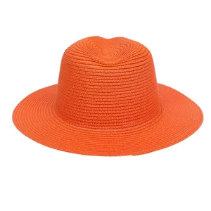 Detailed view of the bright orange woven straw hat featuring a breathable wide brim