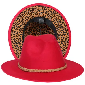 Dettaglio del cappello fedora rosso con tesa leopardata e nastro decorativo intrecciato