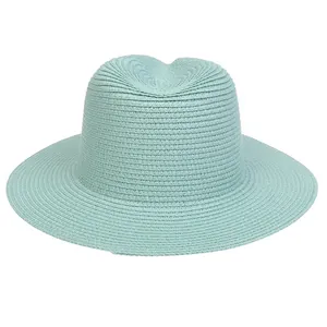 Detail of mint green straw hat showing delicate spiral weave texture and flat wide brim