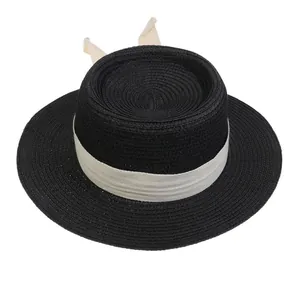 Detail of black straw boater hat with white herringbone ribbon and elegant bow