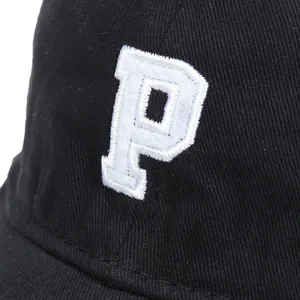Primer plano del bordado blanco 3D de la letra P en una gorra de béisbol negra