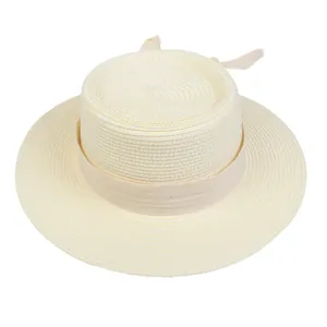 Macro detail of the woven straw texture and ribbon on the beige boater hat