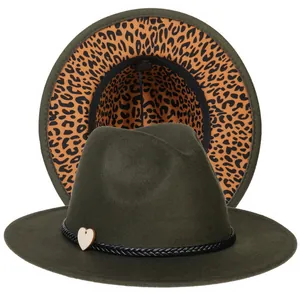 Dettaglio del cappello fedora verde con tesa leopardata e ciondolo a cuore in legno