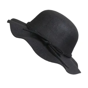 Detailed macro view of black wool felt hat featuring elegant wavy brim and ribbon decoration