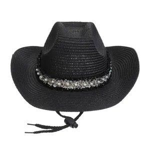 Detail eines gewebten Cowboy-Strohhuts mit schwarz-weißem Perlenband und Windschutzkordel