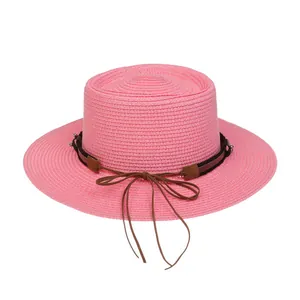 Detail eines rosa Strohhuts mit feinem Geflecht und braunem Schleifenband für Damen