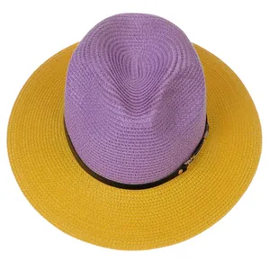 Detail view of woven straw fedora featuring purple crown and yellow brim with belt strap
