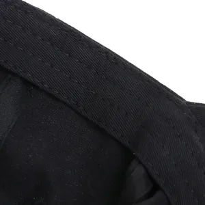 Vista detallada de las costuras reforzadas y la textura de algodón sarga en la gorra negra