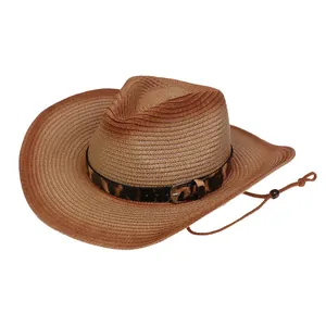 Detalle de sombrero de paja marrón con banda de leopardo y hebilla de metal vintage