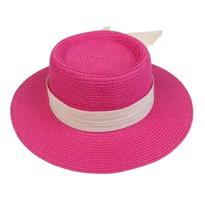 Close-up of rose red straw boater hat featuring a cream herringbone ribbon bow detail