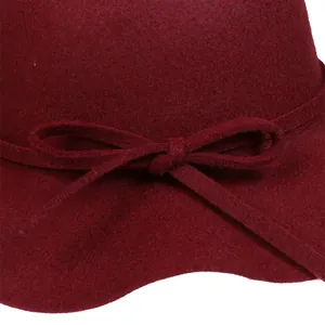 Macro shot of burgundy wool felt fabric showing delicate texture and bow detail