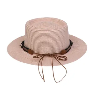 Detailansicht eines rosa Strohhuts mit dunklem Band und brauner Lederschleife für Damen