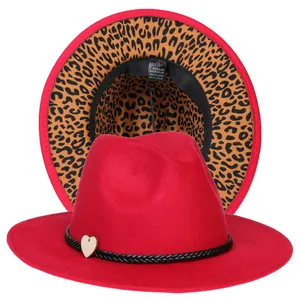 Dettaglio del cappello fedora rosso con tesa interna leopardata ed etichetta materiale