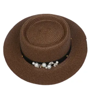 Detail of dark brown boater hat with pearl and white flower accents on black ribbon