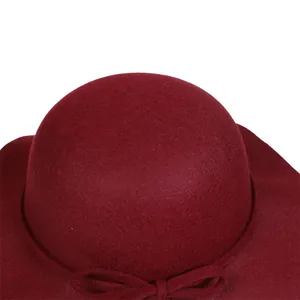 Detail of the elegant dark red wool felt hat with decorative bow and wavy brim