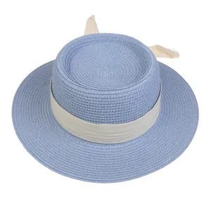 Detail of blue straw boater hat featuring ivory herringbone ribbon and decorative bow knot