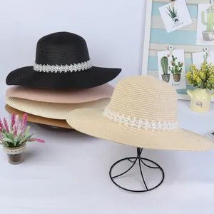 Detail of wide brim straw hats with elegant pearl lace bands in various colors