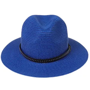 Detail of royal blue woven sun hat featuring a black leather band with silver metal studs