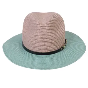 Detail of two-tone panama straw hat with black leather strap and metal buckle